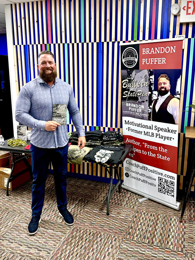 Faith-based author and motivational speaker Brandon Puffer holding his book From the Bullpen to the State Pen, sharing his redemption story and message of second chances.