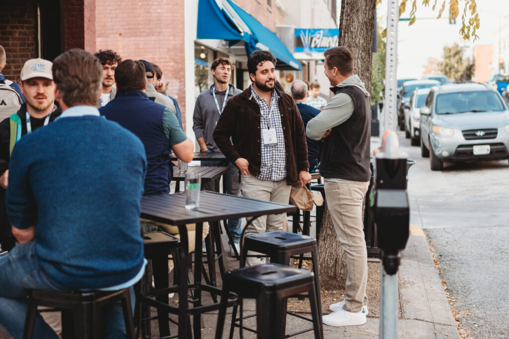 Business professionals networking at outdoor cafe discussing thought leadership and professional development