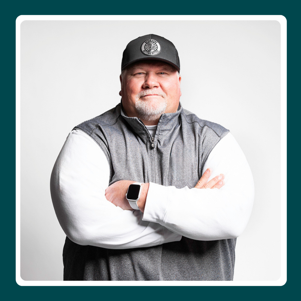 Photo of John Perry, head football coach and author, holding Never Stop Getting Better, personal growth book football coach.